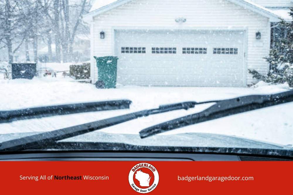 Snow covered driveway and garage in Wisconsin, highlighting winter strain on doors that Badgerland Garage Door provides service to fix.