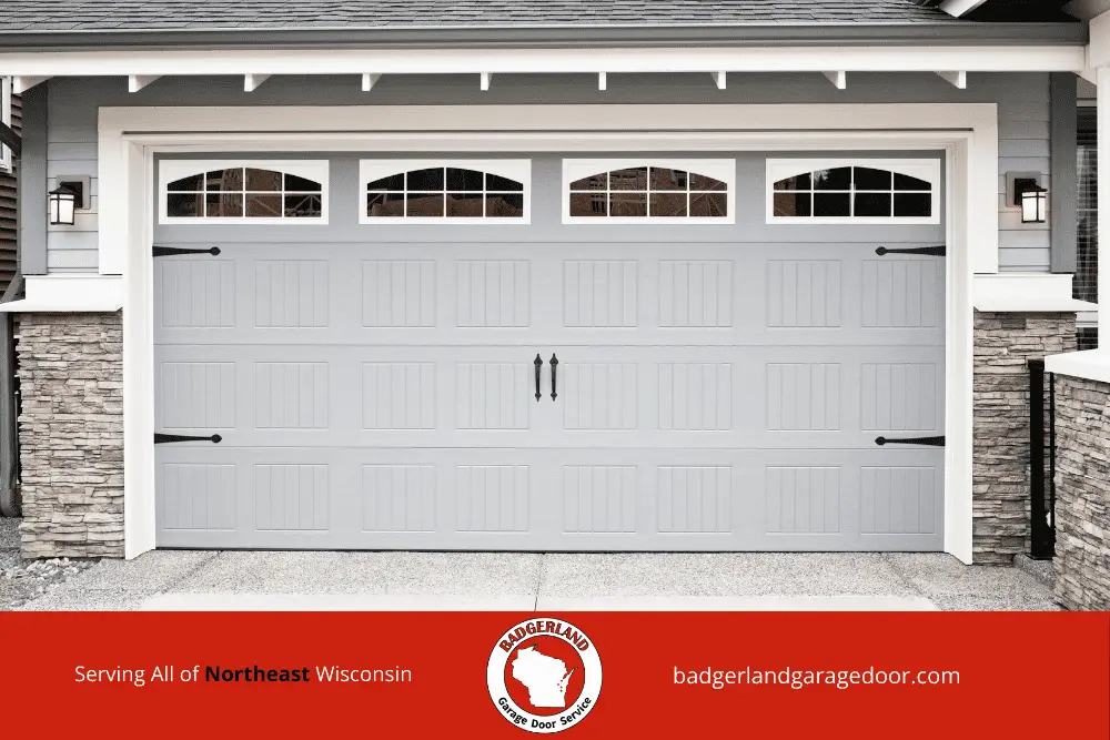 How Cold Weather Affects Garage Door Cables and Pulleys in Wisconsin-1 A modern garage door with stone accents, promoting Badgerland Garage Door Repair services in Appleton and Green Bay.| Badgerland Garage Door Service – Green Bay Garage Door Repair