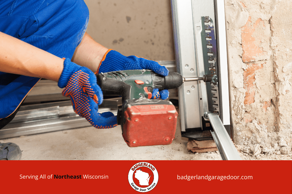 A technician in blue gloves uses a drill for garage door repair in Green Bay.| Badgerland Garage Door Service – Green Bay Garage Door Repair